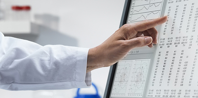 Medical Researcher hand pointing at data on computer monitor for Cedars-Sinai Biostatistics and Bioinformatics Core program.