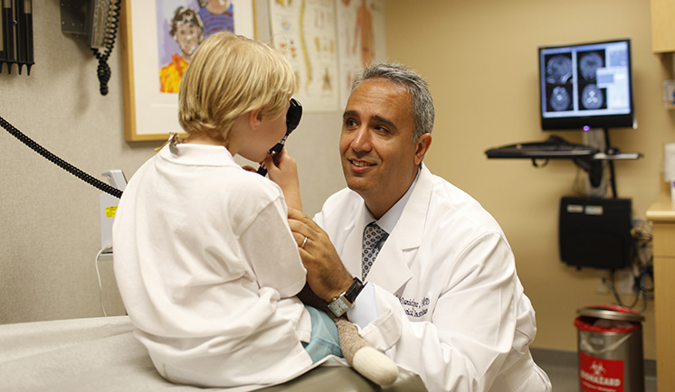 Moise Danielpour, MD checking child patient.