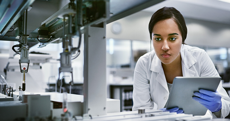 Scientist in a lab holding a tablet.
