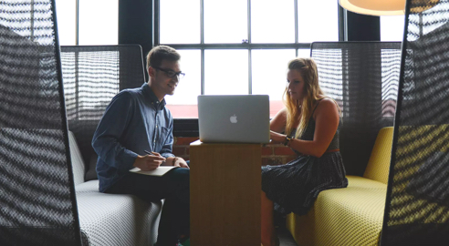 A man and woman using a laptop.