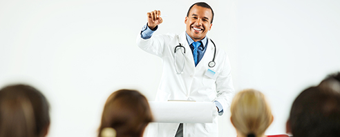 Group of doctors on a seminar. The focus is on cheerful African-American man giving a speech.